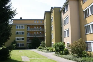 Rückansicht der drei Mehrfamilienhäuser in Muri, verwaltet von AW Immobilientreuhand, mit 33 Wohneinheiten, umgeben von Grünflächen.