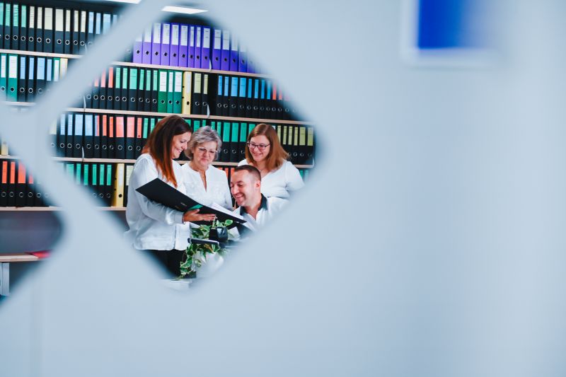 Das Team von AW Immobilientreuhand bespricht Unterlagen in ihrem Büro.